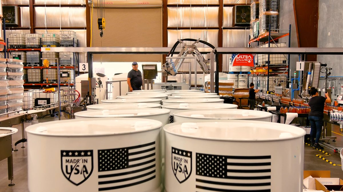Workers on the drum filling and labeling production line