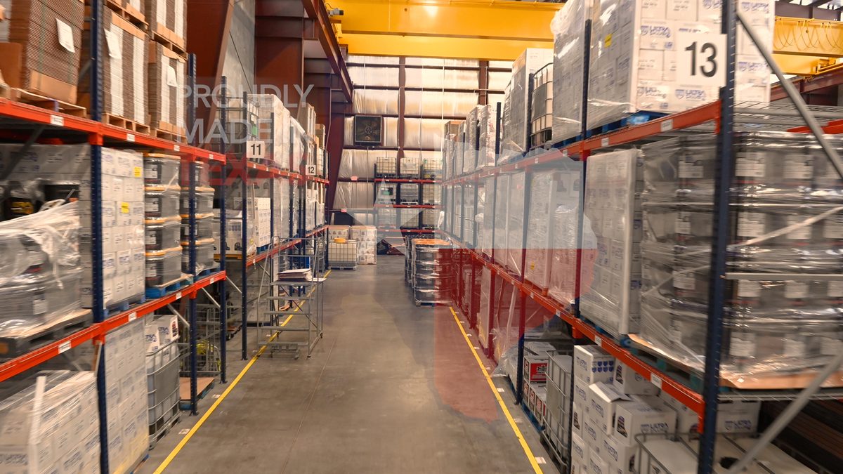 Warehouse aisle with palletized lubricant inventory at U1Dynamics