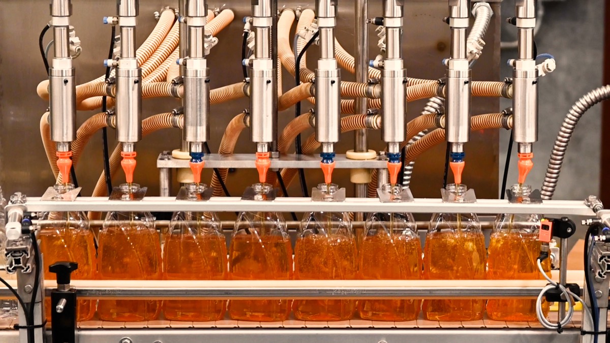 Gallon bottles being filled with lubricant at U1Dynamics facility